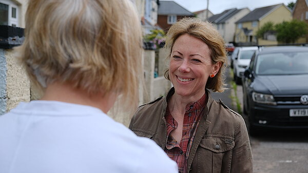 Charlotte smiling at a local resident standing in the street